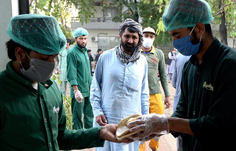 People line up to receive free food as the time to break the fast approaches during the Muslim holy month of Ramadan amid lockdown of the Punjab province due to the ongoing coronavirus COVID-19 disease pandemic in Islamabad, Pakistan. Muslims around the world celebrate the holy month of Ramadan, by praying during the night time and abstaining from eating, drinking, and sexual acts during the period between sunrise and sunset. Ramadan is the ninth month in the Islamic calendar and it is believed that the revelation of the first verse in Koran was during its last 10 nights.  EPA