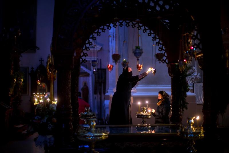 A Lithuanian Orthodox Church believers light candles before the Orthodox Christmas celebration Mass in the empty Orthodox Church of the Holy Spirit in Vilnius, Lithuania. AP Photo