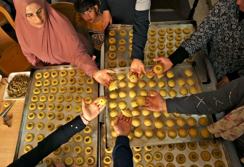 Palestinian women make traditional date and nut-filled biscuits to mark Eid Al Fitr, in the West Bank city of Hebron. AFP