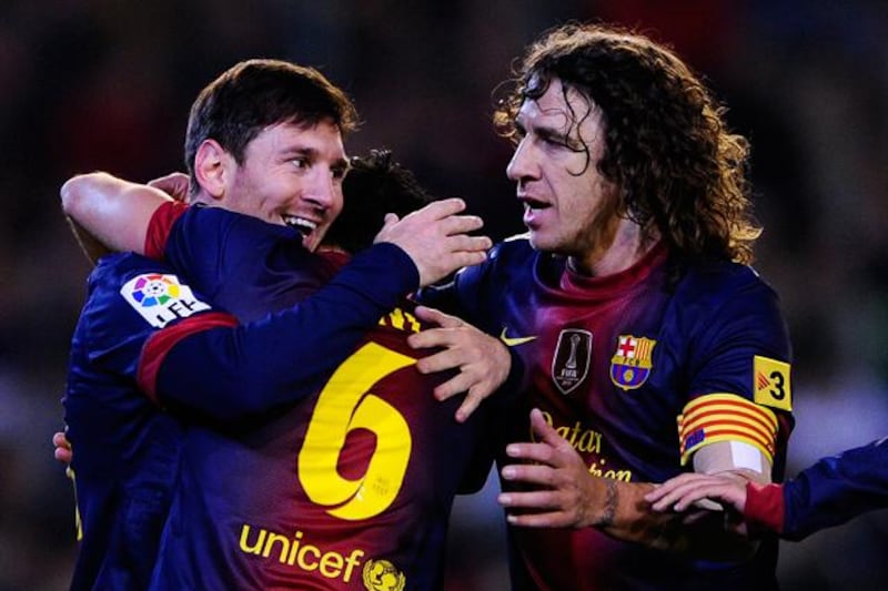 SEVILLE, SPAIN - DECEMBER 09:  Lionel Messi of FC Barcelona (R) celebrates with his teammates Xavi Hernandez (C) and Carles Puyol of FC Barcelona after scoring his team's second goal the La Liga match between Real Betis Balompie and FC Barcelona at Estadio Benito Villamarin on December 9, 2012 in Seville, Spain. With this goal Lionel Messi beats the 1975 scoring record set by Gerd Muller of 85 goals in one year.(Photo by David Ramos/Getty Images)