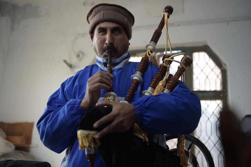 A Pakistani worker tests a set of bagpipes at the factory. Pakistani bands often put the emphasis on how they look, rather than musical technique. AFP.