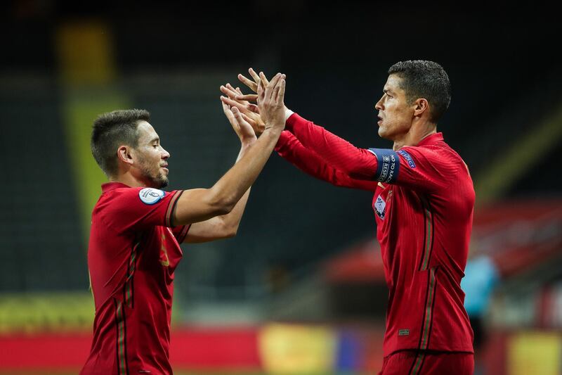 Cristiano Ronaldo celebrates with Raphael Guerreiro after scoring a goal against Sweden, his 100th for Portugual. EPA