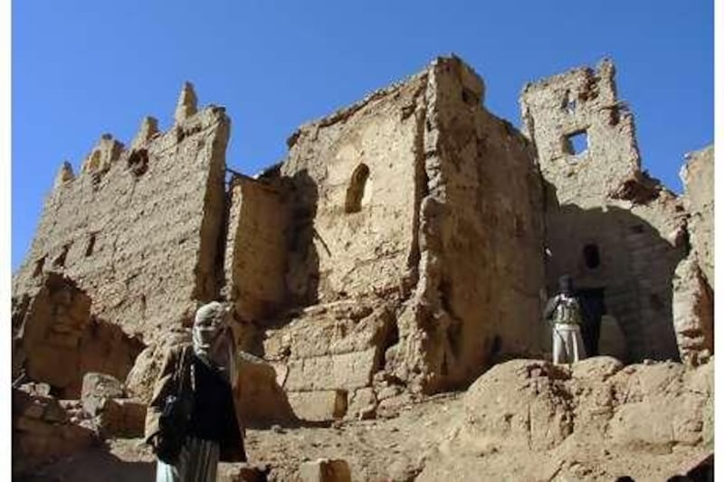 Yemeni Houthi rebels stand amid destroyed mudbrick buildings in central Sa'ada, north of the capital Sana'a, in February, three weeks after a truce was declared between the rebels and government forces.