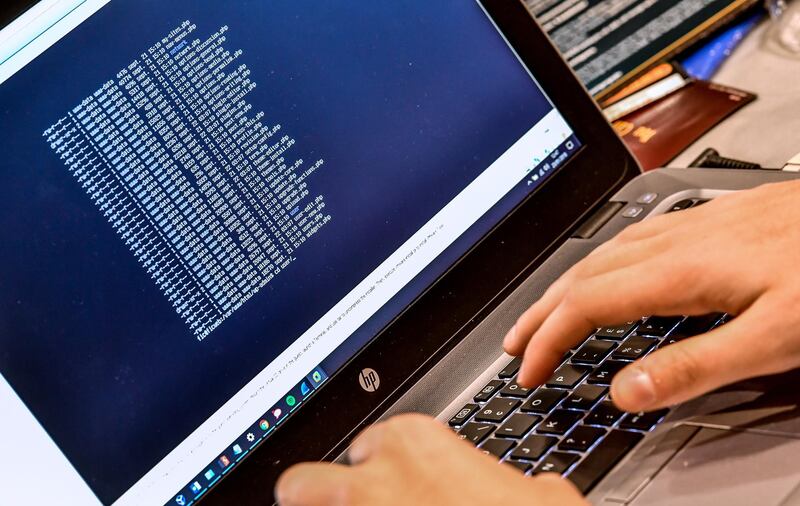 (FILES) In this file photo taken on January 23, 2018 a person works at a computer during the 10th International Cybersecurity Forum in Lille, France. 
The threat of cyberattacks against the US is at a "critical point," the country's intelligence chief has warned, branding Russia the most "aggressive foreign actor" ahead of President Donald Trump's meeting with Vladimir Putin. / AFP PHOTO / PHILIPPE HUGUEN