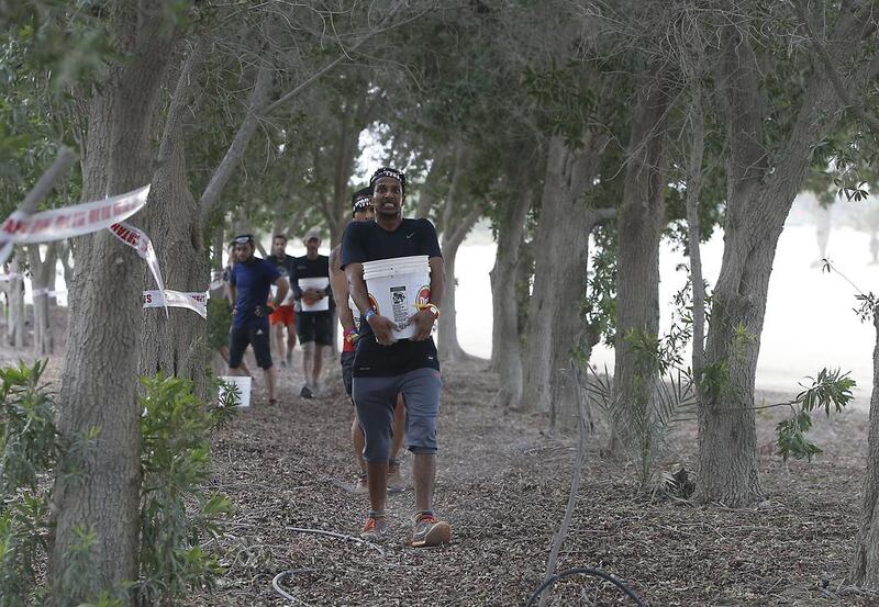 Elite super participants carry buckets as part of the XDubai Spartan Race at Al Ghazal Golf Club in Abu Dhabi. Ravindranath K / The National / February 24, 2017