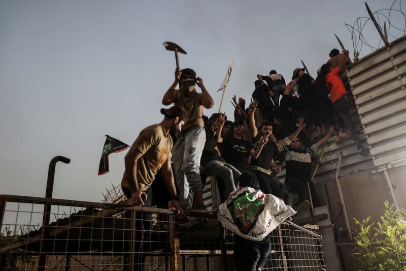 Protesters climb a fence as they gather near the Swedish embassy in Baghdad hours after it was stormed and set on fire ahead of an expected Quran burning in Stockholm. Reuters