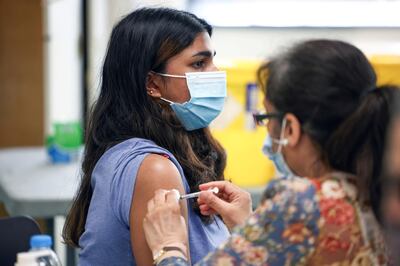 FILE PHOTO: A person receives a dose of the Pfizer BioNTech vaccine at a vaccination centre for those aged over 18 years old at the Belmont Health Centre in Harrow, amid the coronavirus disease (COVID-19) outbreak in London, Britain, June 6, 2021. REUTERS/Henry Nicholls/File Photo