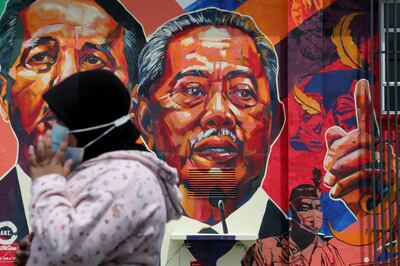 A woman passes by a mural depicting Malaysia's Prime Minister Muhyiddin Yassin in Kuala Lumpur, Malaysia October 27, 2020. REUTERS/Lim Huey Teng