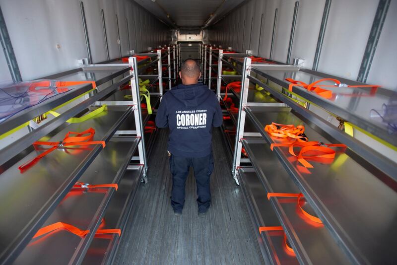 A Los Angeles County Department of Medical Examiner-Coroner staff member inspects a refrigerated container set up to handle additional storage of Covid-19 decedents in Los Angeles, California, USA. Reuters