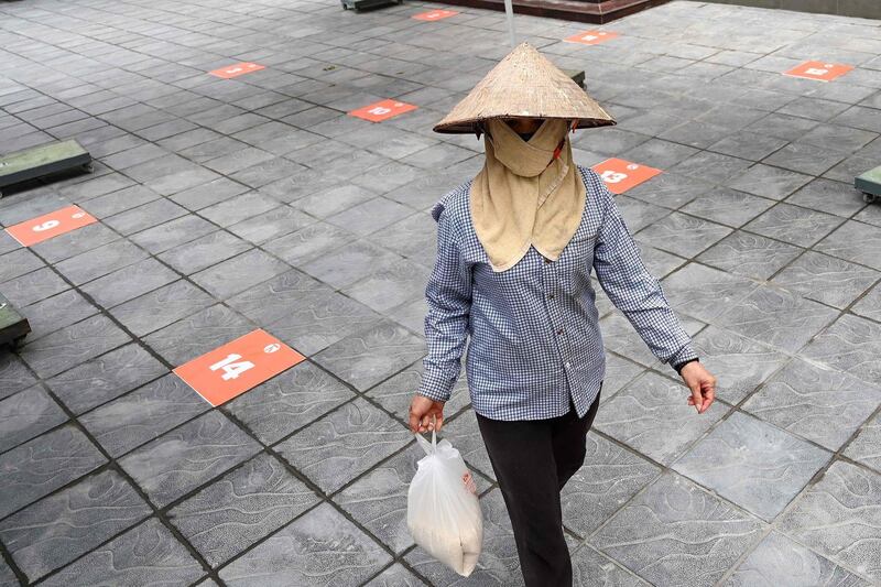 A woman walks with a bag of free rice amid Vietnam's nationwide social isolation effort, in Hanoi.  AFP