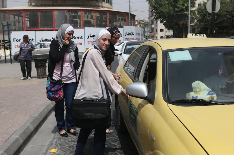 Makers of the initiative Taxi For Women in Jordan Rahma (front) , Maha (R) and Sura (L) look for a cap in a street in Amman, Jordan. (Salah Malkawi for The National)  *** Local Caption ***  SM006_Taxi.jpg