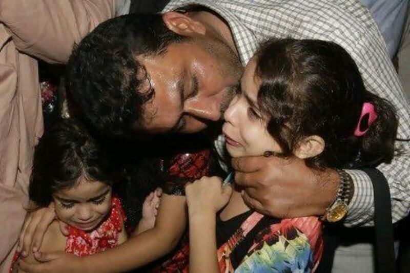 Pakistani ship officer Mohammad Mujtaba meets his children upon arrival at Karachi airport on Thursday, August 2, 2012 in Pakistan. AP Photo / Fareed Khan