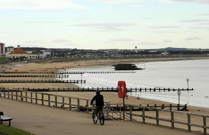 A cyclist rides past the beach in Aberdeen, Scotland. Russell Cheyne / Reuters