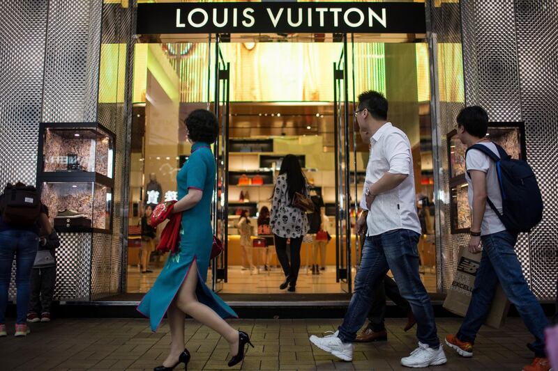 Pedestrians and shoppers walk past a Louis Vuitton store, operated by LVMH Moet Hennessy Louis Vuitton SA, on Canton Road in the Tsim Sha Tsui area of Hong Kong, China, on Saturday, April 18, 2015. Hong Kong is scheduled to release consumer price index (CPI) figures on April 21. Photographer: Billy H.C. Kwok/Bloomberg