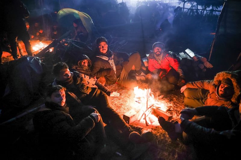 Migrants warm themselves near a fire in Grodno, Belarus. AP Photo