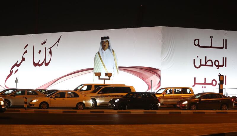 (FILES) In this file photo taken on June 11, 2017 A general view taken on June 11, 2017 shows a portrait of Qatar's Emir Sheikh Tamim bin Hamad Al-Thani and text reading in Arabic: "We are all Tamim" on a billboard outside the Qatar Sports club in Doha after the diplomatic crisis surrounding Qatar and the other Gulf countries spilled from social media to more traditional forms of media -- all the way back to billboards.
 The year-old acrimonious dispute between Qatar and its neighbours is forging a "new" Gulf, potentially transforming what was a stable region of the Arab world, experts warn.
 / AFP / Karim JAAFAR
