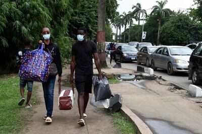 Students carry luggage as they leave as directed by authorities of the University of Lagos to halt the spread of Covid-19 on Campus in Yaba, Lagos, on July 15, 2021. AFP