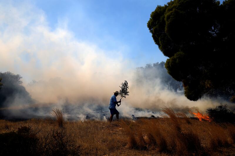 A local tries to extinguish a fire in Markati