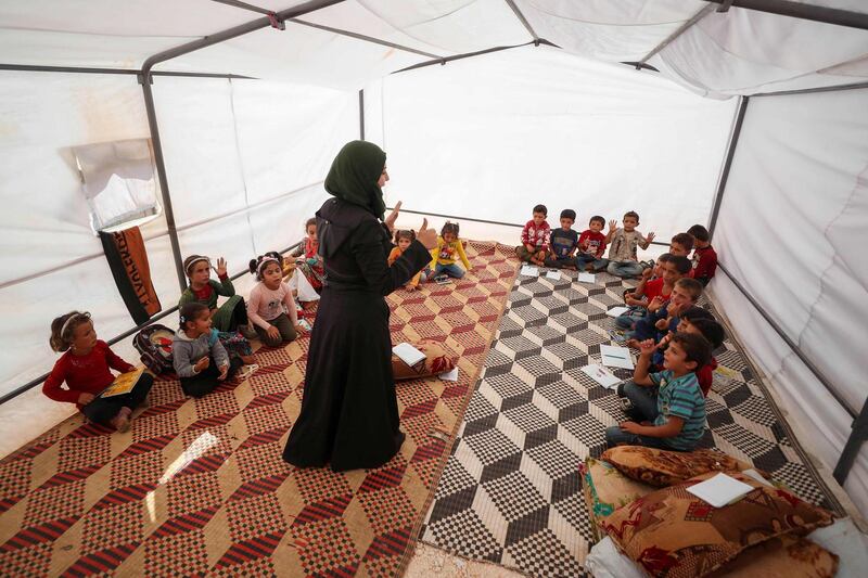 Syrian youths attend classes at a camp for the internally displaced in the town Maarrat Misrin in the country's northwestern Idlib province. AFP