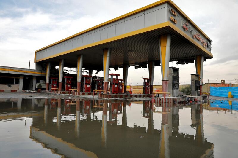FILE - In this Nov. 20, 2019, file photo, a gas station that was attacked during protests over rises in government-set gasoline prices is reflected in a puddle, in Tehran, Iran. Internet connectivity is trickling back in Iran after the government shut down access to the rest of the world for more than four days in response to unrest apparently triggered by a gasoline price hike. (AP Photo/Ebrahim Noroozi, File)