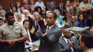 (FILES) Double murder defendent O. J.  Simpson (C), looks at a new pair of Aris extra-large gloves which the prosecutors had him put on for the jury on June 21, 1995 during the OJ Simpson double murder trial in Los Angeles.  The gloves were the same type found at the Bundy murder scene and the OJ Simpson estate.  Simpson, the American football star whose 1995 acquittal in the so-called "trial of the century" for the murder of his ex-wife and a male friend gripped the world, has died at the age of 76.  (Photo by Vince BUCCI  /  AFP)
