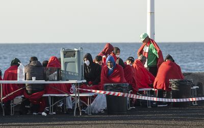 A group of migrants rest in a Spanish port after being rescued by coastguards. EPA 