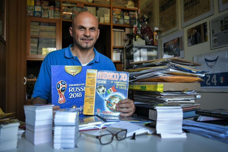 Gianni Bellini, owner of the largest Panini football stickers collection in the world, poses for a picture with  with the 1970 Mexico World Cup Panini album, one of the rarest pieces in his collection, in his studio in San Felice sul Panaro, Modena, on July 18, 2018. / AFP / Piero CRUCIATTI
