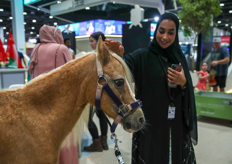 Woman pets horse at Adihex. Victor Besa / The National