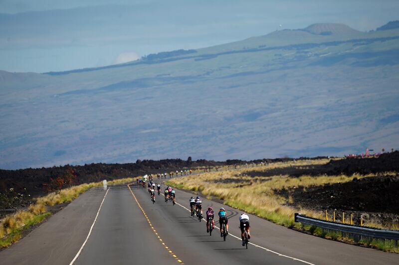 Mauna Loa looms in the background as competitors ride the bicycle portion of the Ironman World Championship Triathlon in Kailua-Kona, Hawaii. Marco Garcia / AP Photo