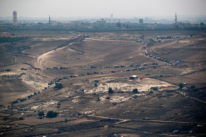 epa06925690 A view of Syrian people fleeing fighting between forces loyal to the Syrian regime and Islamic State (IS) militants in the village of Maariyah, located at Syria-Jordan-Israel border triangle, south of the Golan Heights, 03 August 2018, as seen from the Israeli side of the border. According to media reports, the Syrian government forces had recently cleared last pockets of Islamic State militants along the Israeli border on the Golan Heights concluding a six-week campaign.  EPA/ATEF SAFADI