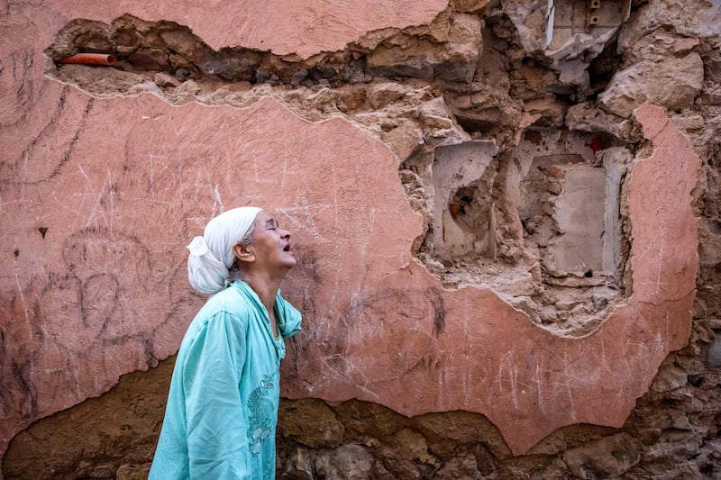 A woman reacts standing in front of her house damaged by an earthquake in the old city in Marrakesh. AFP