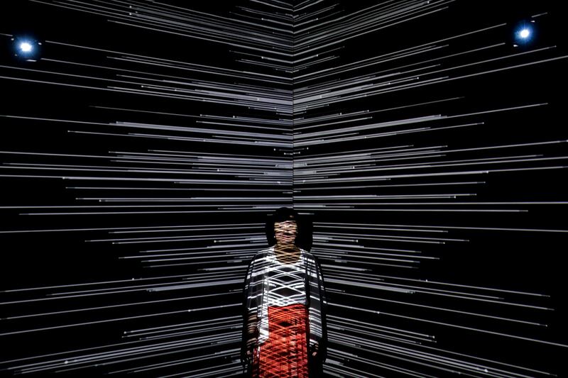 A woman is beamed by light at an art installation titled Infinity Room displayed during The Future of Today Exhibition at Today Art Museum. Andy Wong / AP photo