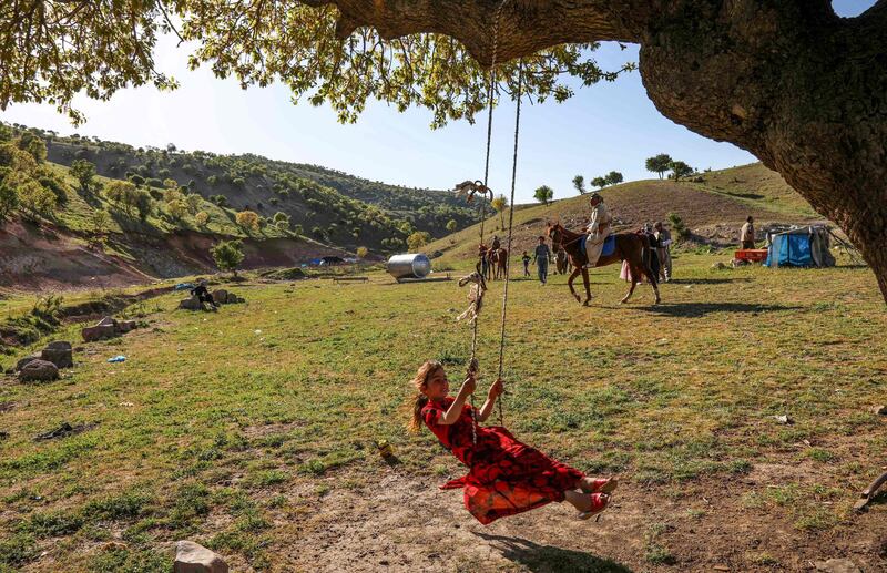A girl rides a swing hanging from a tree branch during the festivities. AFP