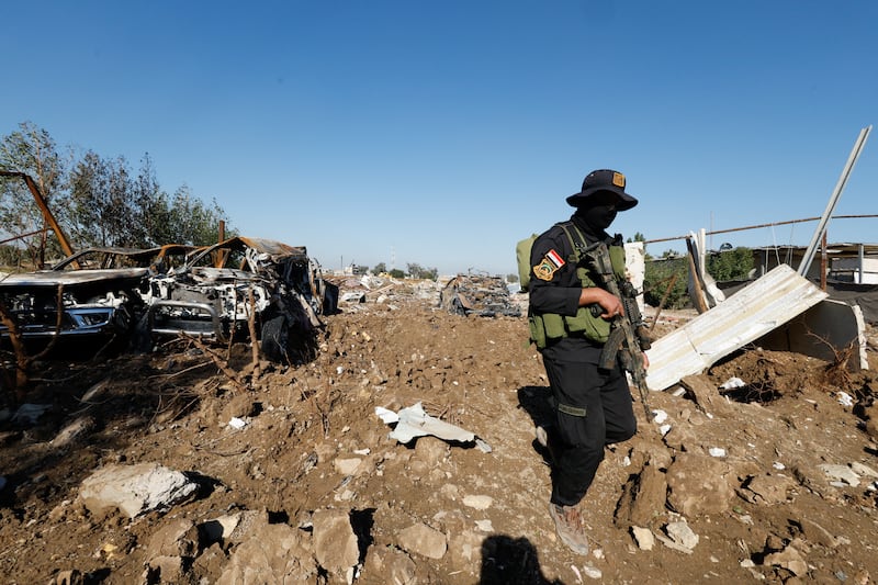 A Kataib Hezbollah militia fighter inspects the site of a US air strike in Hilla, Iraq at the end of last year. Reuters