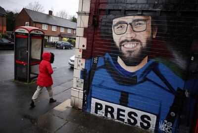 A woman walks by a mural of Palestinian photojournalist Motaz Azaiza in Manchester. Photo: Reuters 