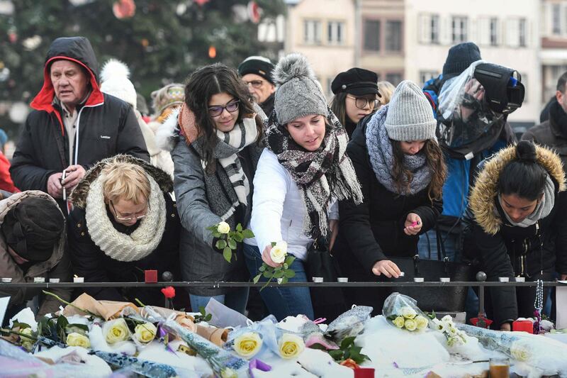 People light candles and deposit flowers. AFP