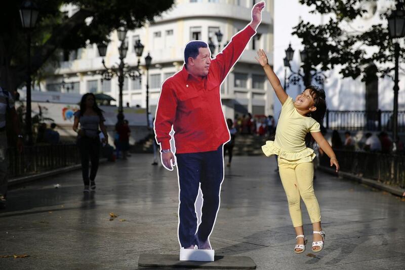 A girls jumps next to a picture of late Venezuela's president Hugo Chavez at Plaza Bolivar in Caracas. Jorge Silva / Reuters