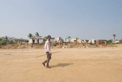 Bhima Rao, 45, walks past the village's suriviving houses in the Bay of Bengal, on India's eastern coast. Taniya Dutta / The National