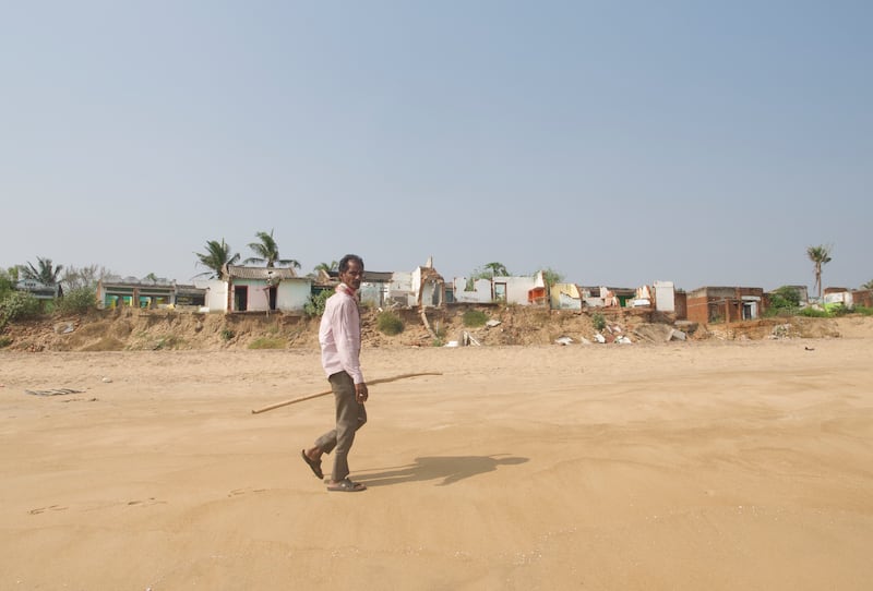 Bhima Rao, 45, is walking past the rows of houses that hold their foundations to the last remaining bits of earth along India's eastern coast in the Bay of Bengal.