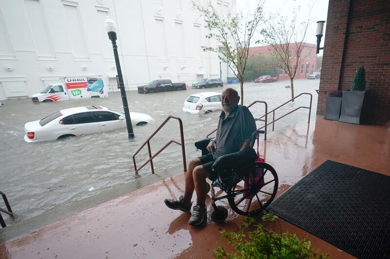 A man watches flood waters in downtown Pensacola, Florida. AP Photo