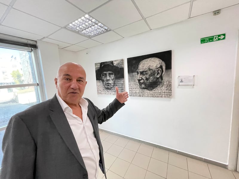 Mr Wahbeh in front of a work by Bahraini artist Jamal Rahim at the EU mission in Amman. Khaled Yacoub Oweis / The National