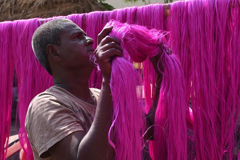 A worker dries out coloured polyster/silk yarn from which garlands are made ahead of the Hindu festival of Diwali in Ahmedabad on October 17, 2019. Colourful garlands are in demand during the Hindu festival of Diwali, or Festival of Lights, which falls on October 27 this year. AFP