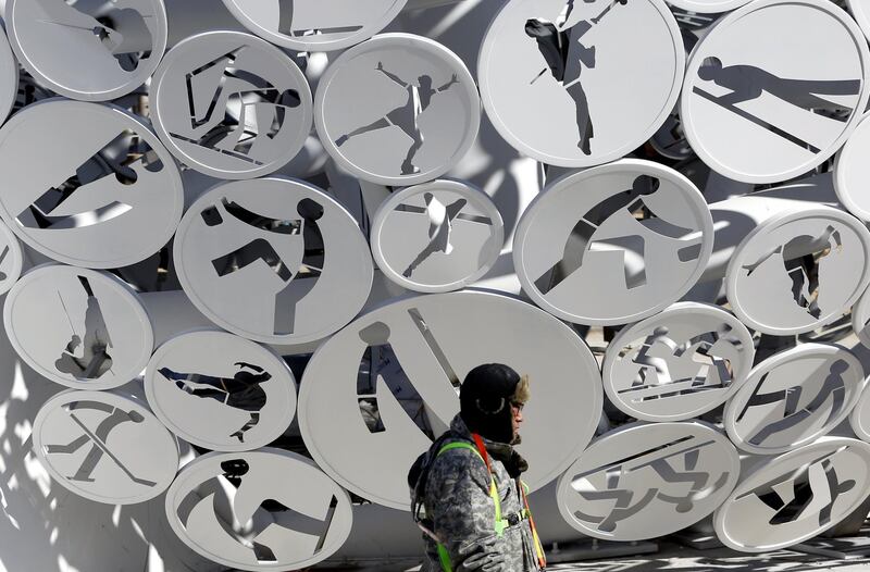 A workman passes discs of Olympic sports decorating a large Olympic sports structure at the Alpensia resort before the start of the Pyeongchang 2018 Olympic Games. Barbara Walton / EPA