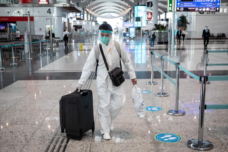 ISTANBUL, TURKEY - JUNE 01: A passenger wearing protective equipment wheels his luggage to a check-in counter at Istanbul Airport on June 01, 2020 in Istanbul, Turkey. As infection rates of the coronavirus continue to drop and after more than a month of weekend lockdowns, Turkey has begun reopening procedures, allowing bars, restaurants and cafes to open under new restrictions for the first time since March 17. Limited domestic flights have restarted and the stay-at-home curfew for citizens under 20 and over 65 has been eased.   (Photo by Chris McGrath/Getty Images)