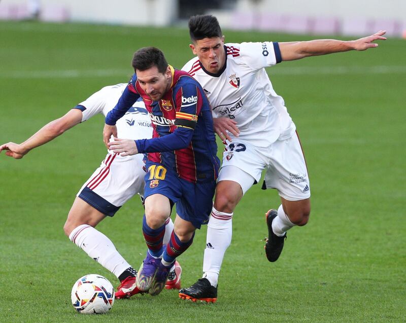 Barcelona's Lionel Messi battles with Osasuna's Raul Navas. Reuters