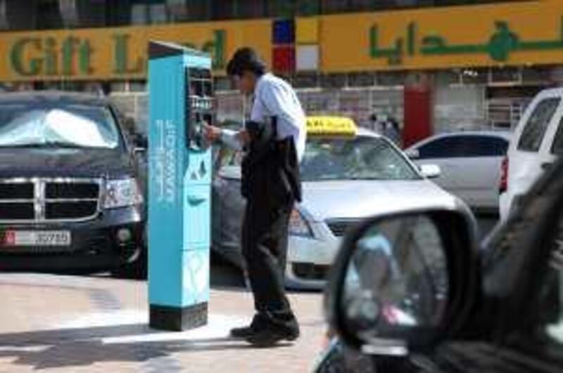 Abu Dhabi, UAE - January 30, 2010 - A taxi driver tries to figure out how to use a new parking meter on Hamdan street, next to the Home Centre. (Nicole Hill / The National)