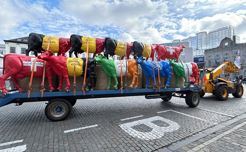 A tractor pulls a trailer filled with plastic cows before a protest by farmers outside of a meeting of EU agriculture ministers in Brussels. AP