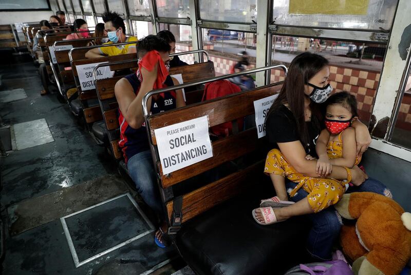Passengers ride a bus with signs arranged for social distancing during the first day of a more relaxed lockdown in Manila, Philippines. AP Photo
