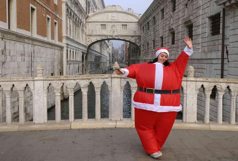 A woman dressed as Santa Claus poses in front of the Bridge of Sighs in Venice. Manuel Silvestri / Reuters