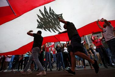 Demonstrators carry national flags during anti-government protests in downtown Beirut. REUTERS